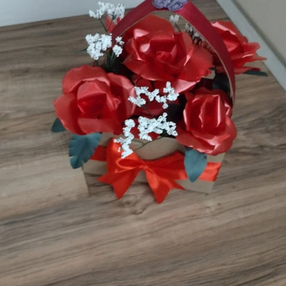 Handmade floral arrangement with plastic ribbon roses.